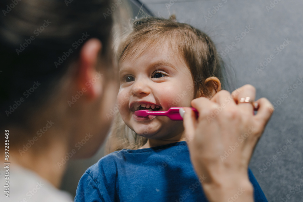 Happy mother and child little baby girl cleaning teeth with a toothbrush in the bathroom. Happy, love and care mom teaching child or kid about dentistry and Happy mother and child little baby girl cleaning teeth with a toothbrush in the bathroom. Happy, love and care mom teaching child or kid about dentistry and