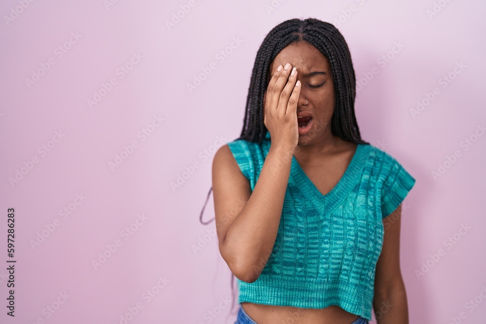Young african american with braids standing over pink background yawning tired covering half face, eye and mouth with hand. face hurts in pain. Young african american with braids standing over pink background yawning tired covering half face, eye and mouth with hand. face hurts in pain.