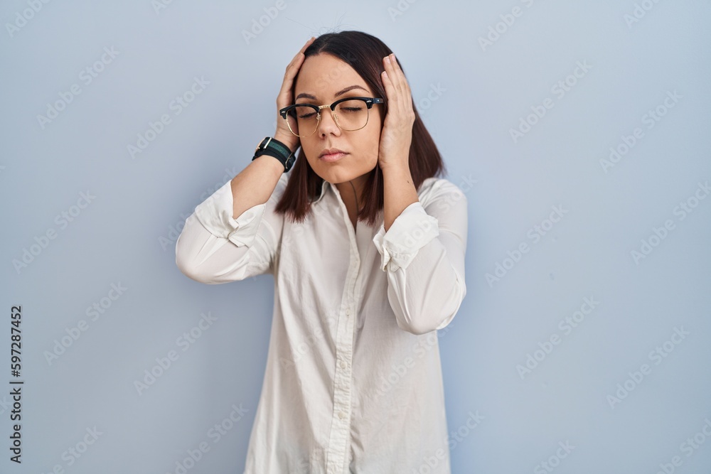 Young hispanic woman standing over white background suffering from headache desperate and stressed because pain and migraine. hands on head. Young hispanic woman standing over white background suffering from headache desperate and stressed because pain and migraine. hands on head.