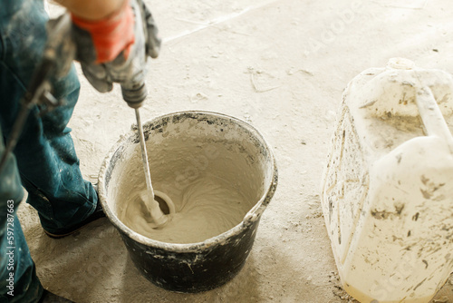 Canvas-taulu Worker mixing gypsum plaster with water for plastering walls