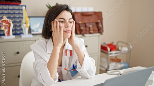 Young caucasian woman doctor stressed working at clinic