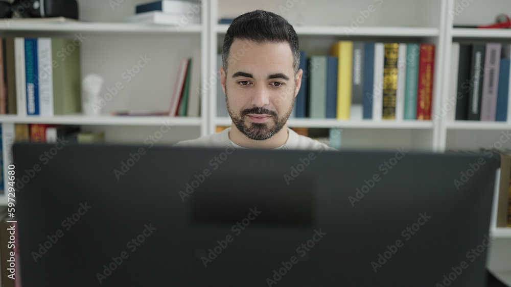 Young hispanic man student using computer studying at library university Young hispanic man student using computer studying at library university