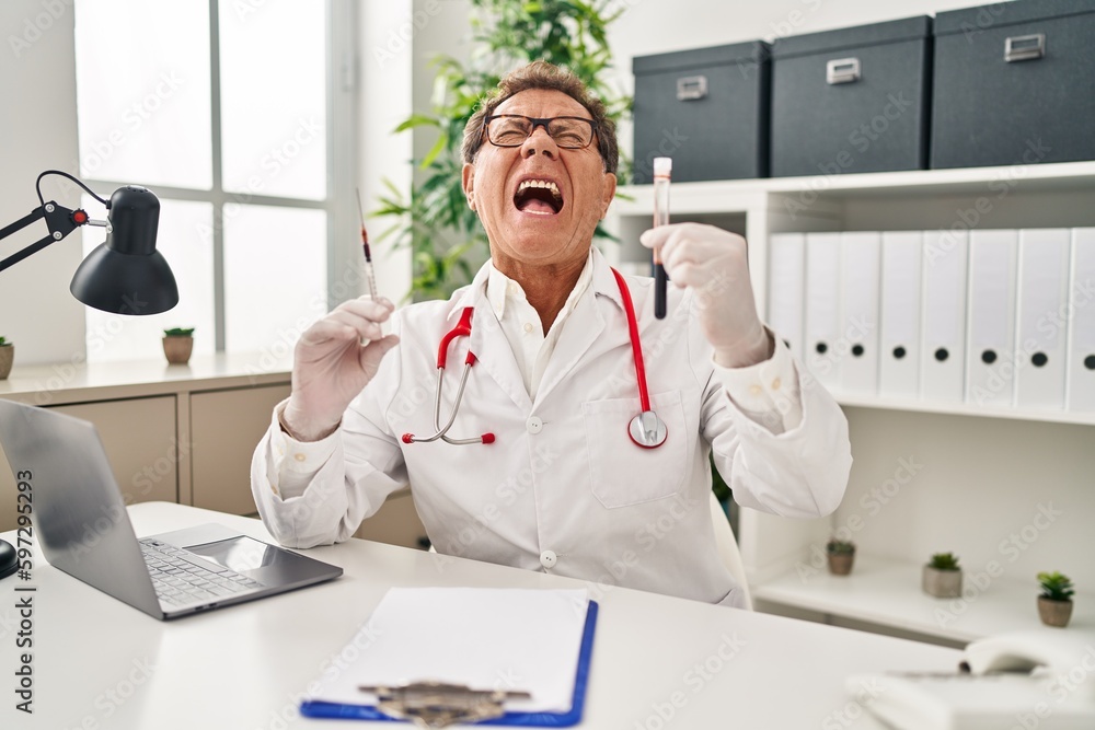 Senior doctor man holding syringe and blood sample angry and mad