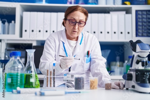 Senior woman scientist holding tweezer at laboratory