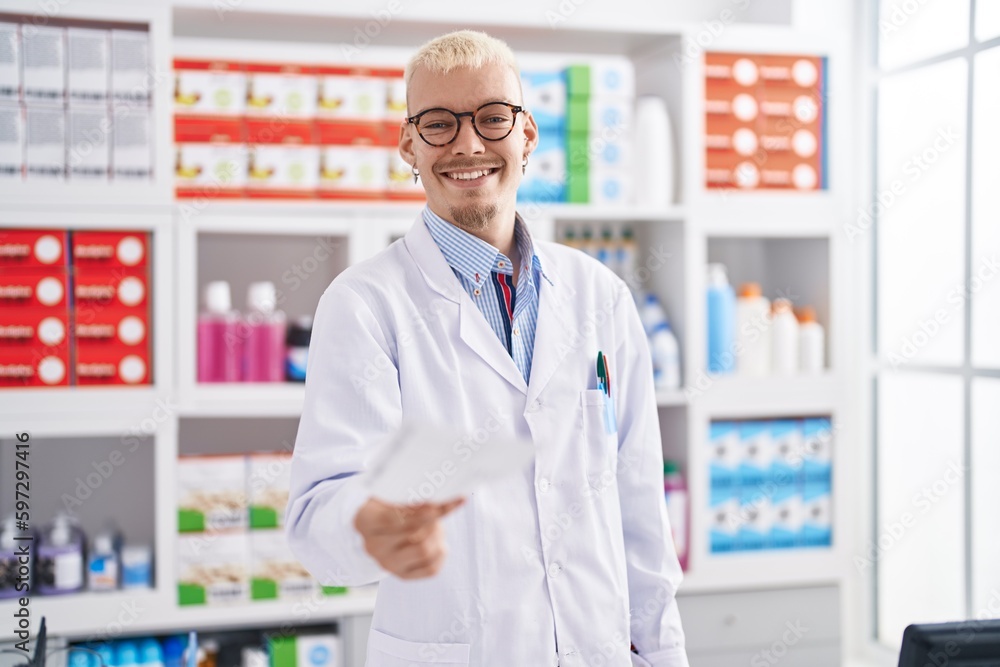 Young caucasian man pharmacist holding prescription at pharmacy