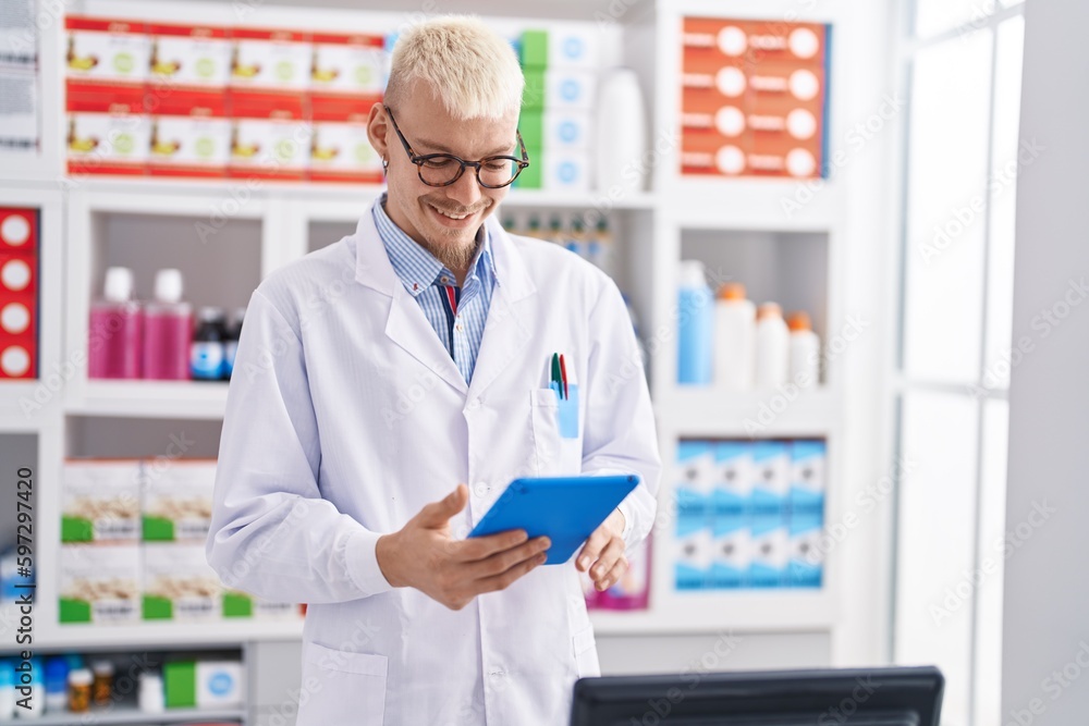 Young caucasian man pharmacist using touchpad working at pharmacy Young caucasian man pharmacist using touchpad working at pharmacy