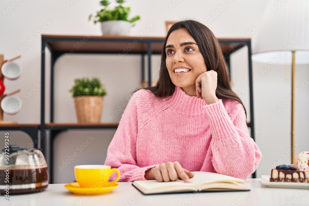 Young hispanic woman reading book having breakfast at home Young hispanic woman reading book having breakfast at home