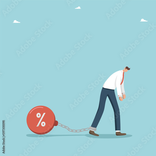 Debt and credit obligations, financial difficulties, borrowing money, paying monthly or annual payments on bank loans, leasing and mortgage, frustrated man chained to a prison ball with a chain.