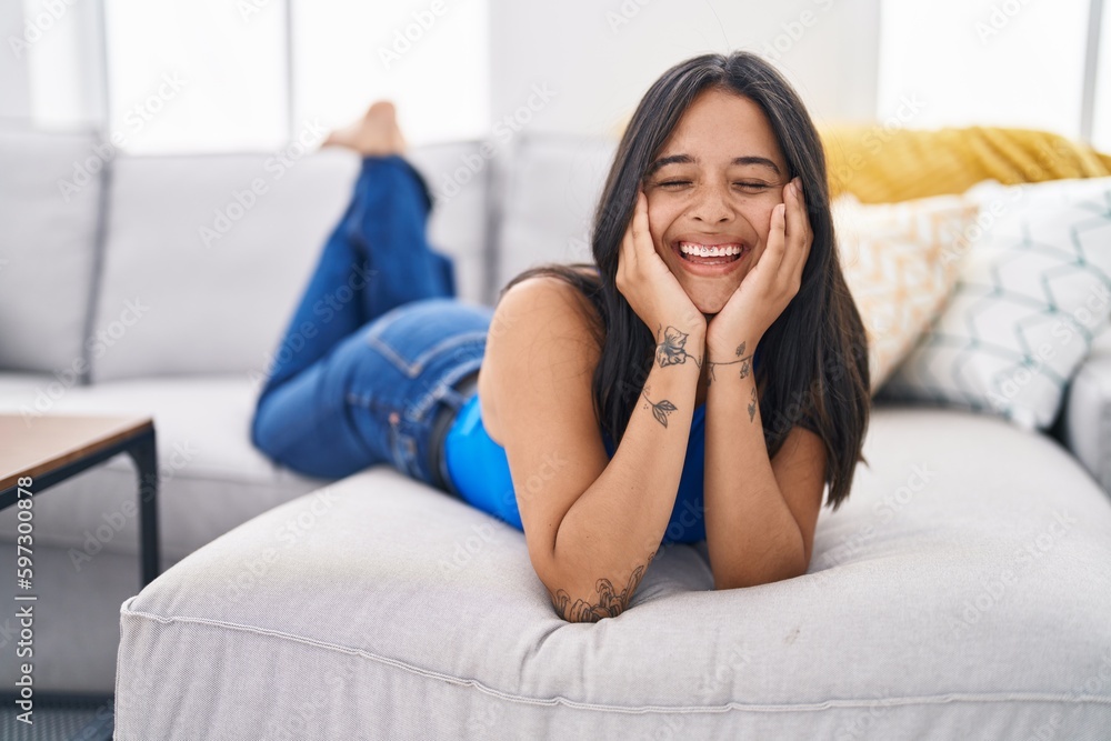 Young hispanic woman smiling confident lying on sofa at home Young hispanic woman smiling confident lying on sofa at home