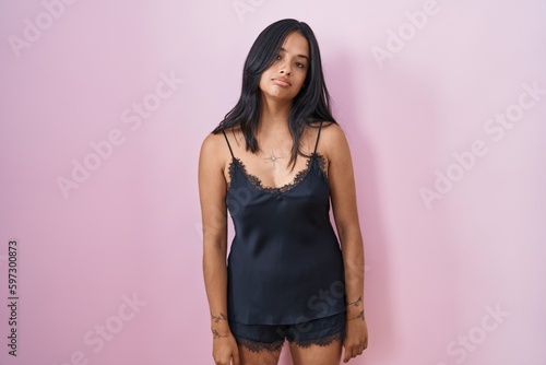 Brunette woman wearing black pajama looking sleepy and tired, exhausted for fatigue and hangover, lazy eyes in the morning. © Krakenimages.com