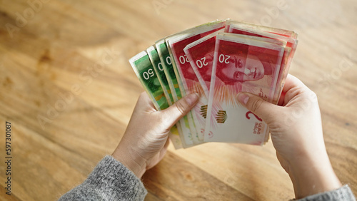 Quadro em tela Hands of woman counting shekels banknotes at room