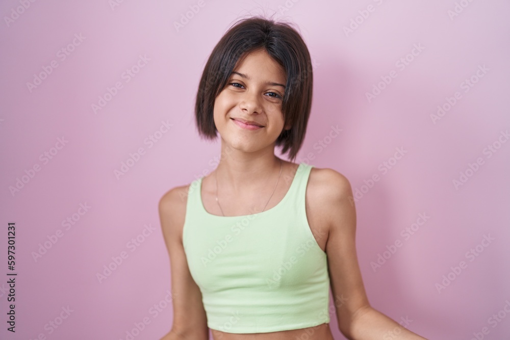 Young girl standing over pink background smiling cheerful with open arms as friendly welcome, positive and confident greetings Young girl standing over pink background smiling cheerful with open arms as friendly welcome, positive and confident greetings