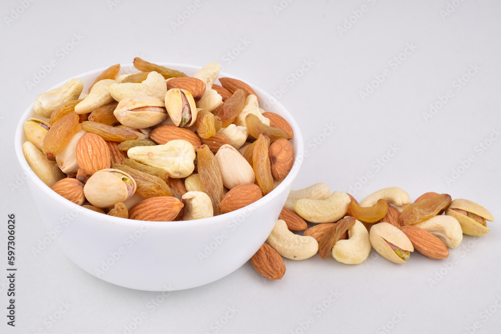 Bowl of mix nuts almond pistachio with raisin and cashew isolated on white background Bowl of mix nuts almond pistachio with raisin and cashew isolated on white background