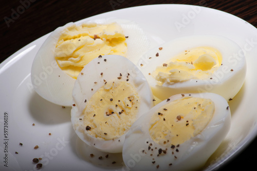 Closeup of boiled egg with seasoned black pepper in plate