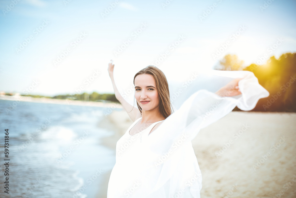 Happy smiling woman in free happiness bliss on ocean beach standing with open hands. Portrait of a multicultural female model in white summer dress enjoying nature Happy smiling woman in free happiness bliss on ocean beach standing with open hands. Portrait of a multicultural female model in white summer dress enjoying nature