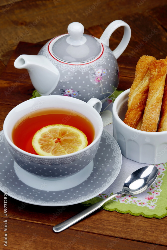Tazza da tè con teiera e pasticcini di pasta sfoglia Tazza da tè con teiera e pasticcini di pasta sfoglia
