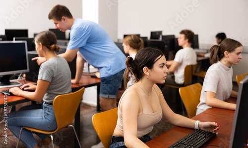 Portrait of female schoolgirl at computers in university computer class