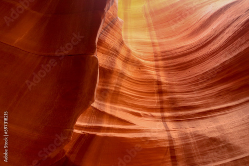 Etched erosion in the sandstone slots of Antelope Canyon with shadows and golden light streaming down the walls at the Navajo Park and Recreation area in Arizona