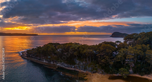 Aerial sunrise seascape with calm seas and a mix of high and low cloud