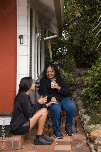 Aboriginal parent sitting together with teen on back porch