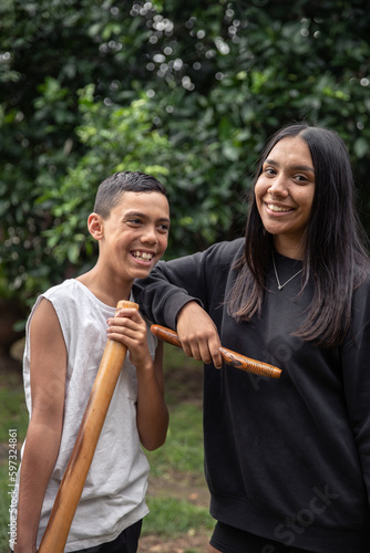 First Nations teenagers holding Indigenous instruments photo