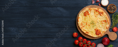 Delicious Megrelian khachapuri served on dark blue wooden table, flat lay. Banner design with space for text