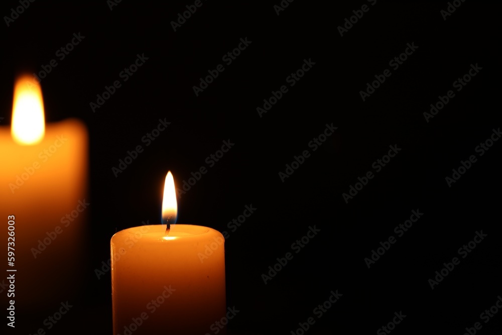 Burning candle on black background, closeup. Space for text Burning candle on black background, closeup. Space for text