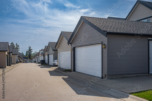 Row of garage doors at parking area for townhouses. Private garages for storage or cars in rows in an alley © Elena_Alex