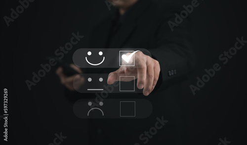 Concept of satisfaction and customer service. : Business man use his finger to touching or pressing the virtual screen the smiley happy face to show satisfaction with the service or give rate. 