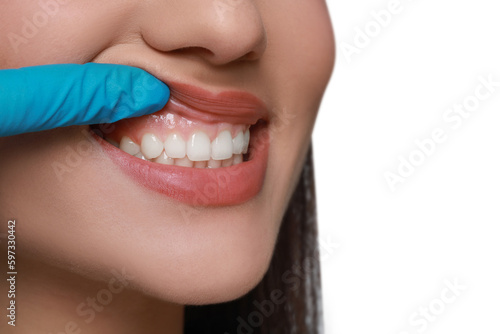 Doctor examining woman's gums on white background, closeup