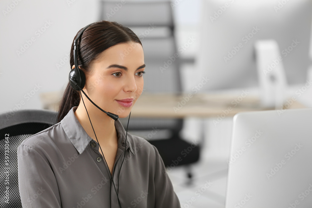 Hotline operator with headset working on computer in office Hotline operator with headset working on computer in office