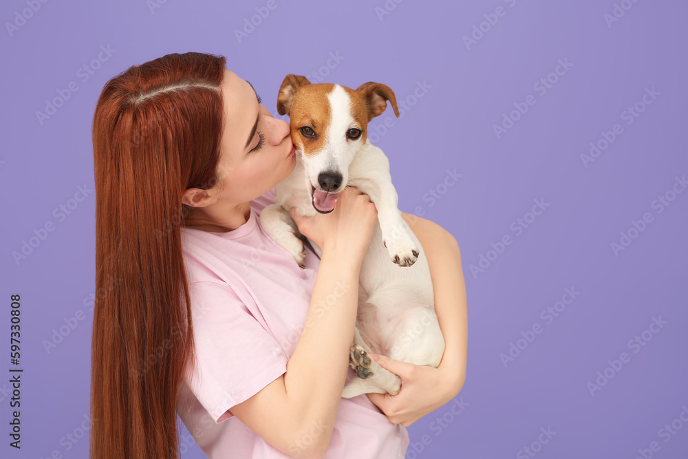 Woman kissing cute Jack Russell Terrier dog on violet background. Space for text Woman kissing cute Jack Russell Terrier dog on violet background. Space for text