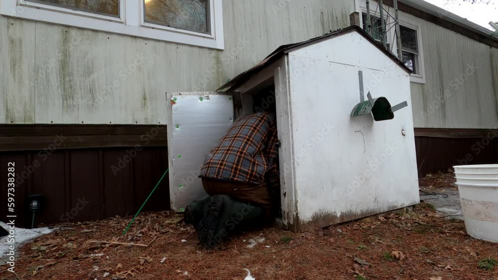 Man partly going into water well shed to fix some issue with pump. Man partly going into water well shed to fix some issue with pump.