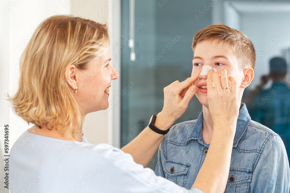 mom glues a patch to remove blackheads to her son. acne remover patch
