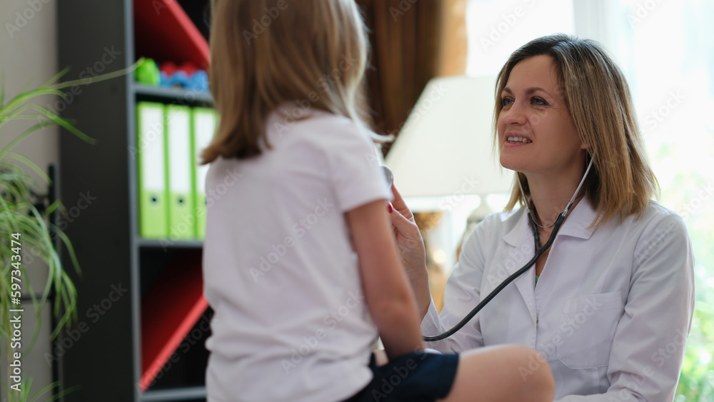Friendly female doctor checks heartbeat of little patient Friendly female doctor checks heartbeat of little patient
