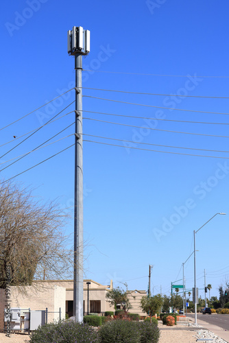 Cellular broadcast antennas attached at the top of tall pylon erected near major road, copy space