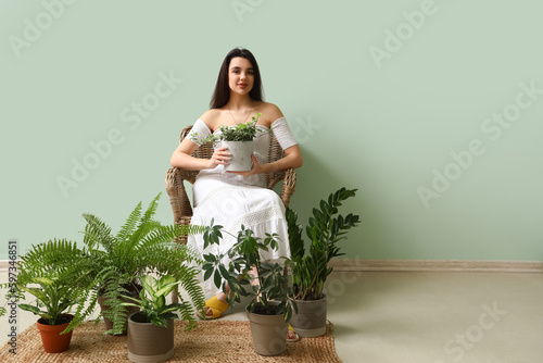 Young woman with houseplant...
