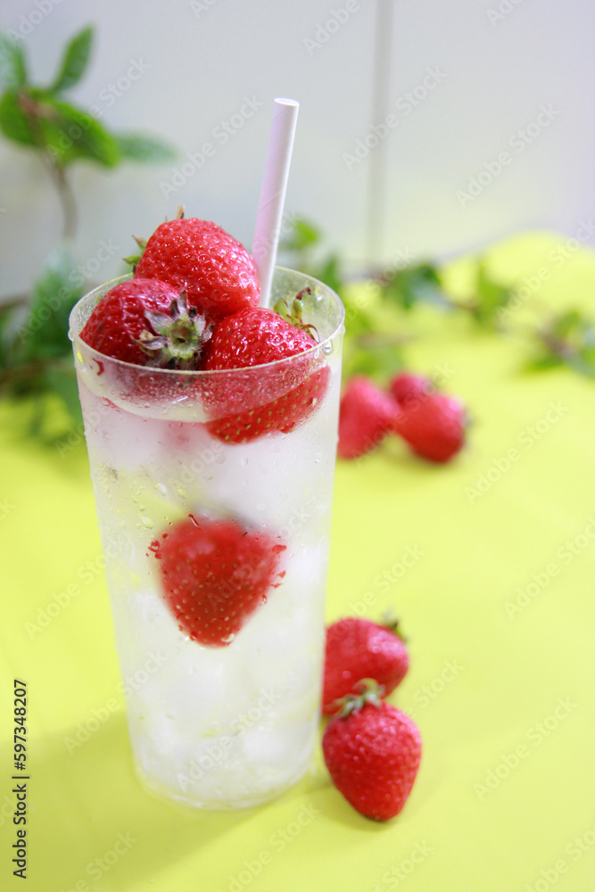 Ice drink concept with fresh strawberries and green leaves background Ice drink concept with fresh strawberries and green leaves background