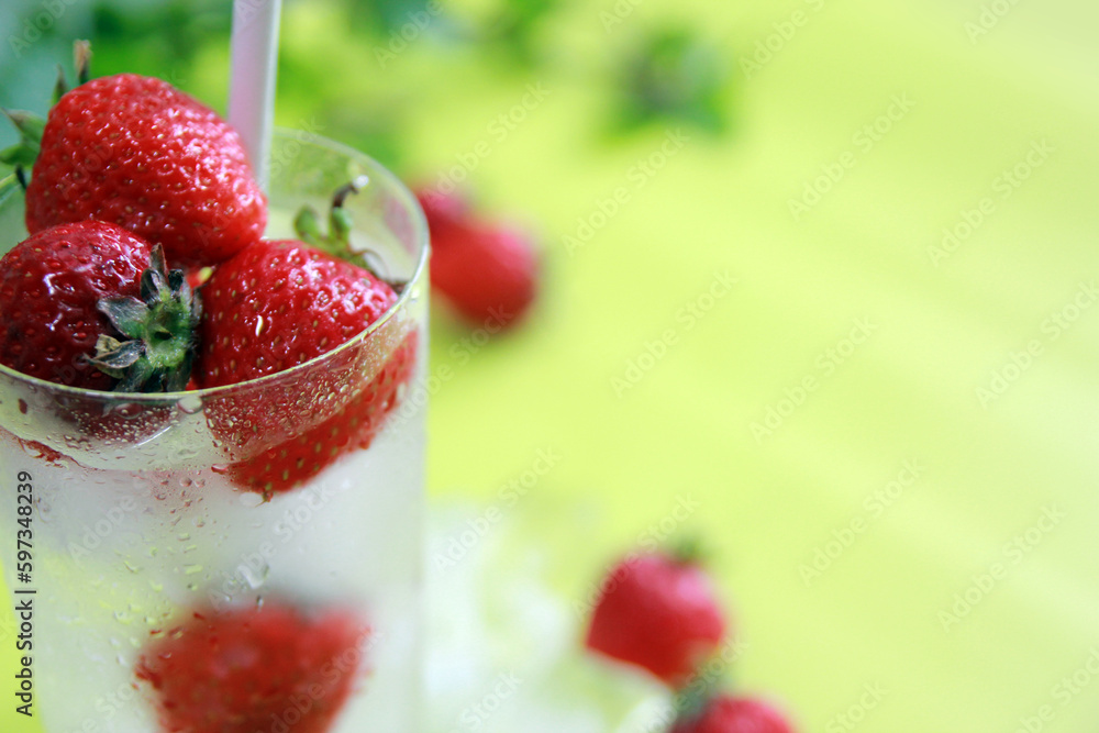 Ice drink concept with fresh strawberries and green leaves background Ice drink concept with fresh strawberries and green leaves background