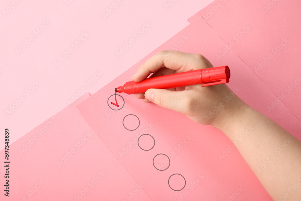 Woman marking on checklist box with red marker Woman marking on checklist box with red marker