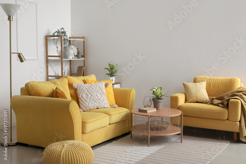 Interior of stylish living room with cozy sofa, armchair and coffee table