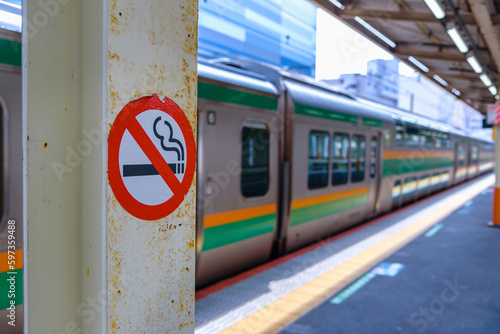 No smoking sign at the pole for no smoking area in train station platform.