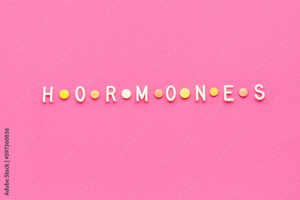Word HORMONES on pink background Word HORMONES on pink background