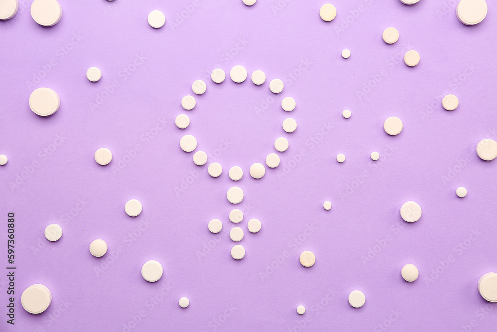 Symbol of woman made with hormonal pills on lilac background Symbol of woman made with hormonal pills on lilac background
