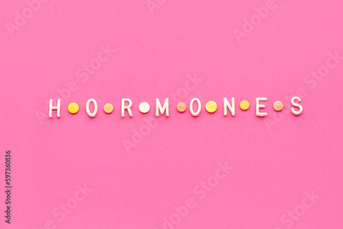 Word HORMONES on pink background