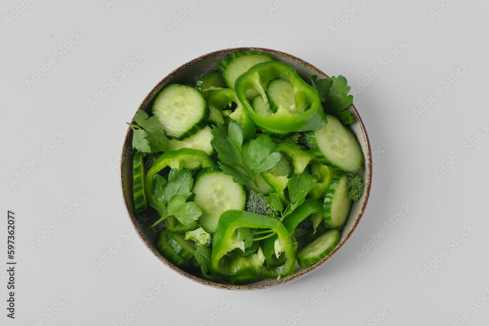 Bowl of salad with green vegetables on grey background Bowl of salad with green vegetables on grey background