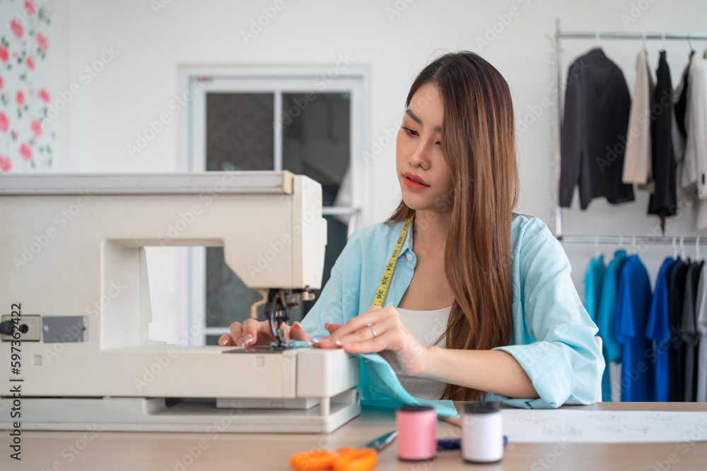Female fashion designer working on sewing machine creating new clothing Female fashion designer working on sewing machine creating new clothing