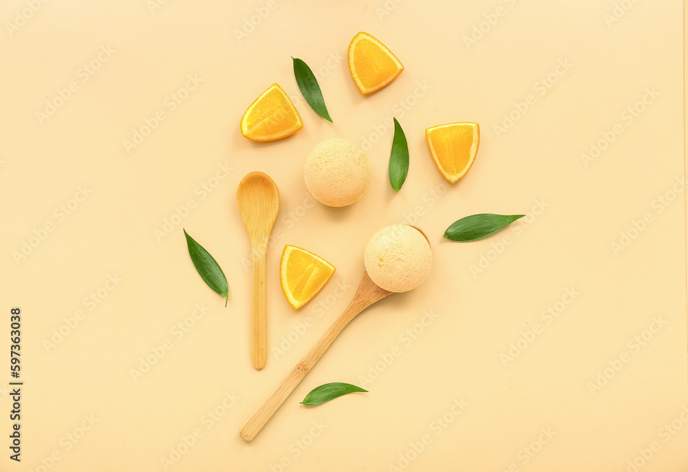 Bath bombs with orange slices, wooden spoons and leaves on beige background Bath bombs with orange slices, wooden spoons and leaves on beige background