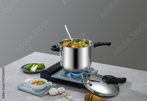 The scene of using a pressure cooker to make soup and cook dishes in the kitchen, marble countertop background, wood grain desktop