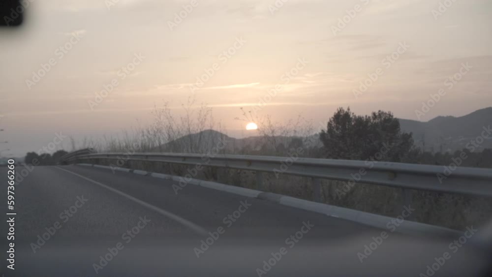 Watching the sunset while driving the car with an overview of the road ahead in slowmotion LOG
